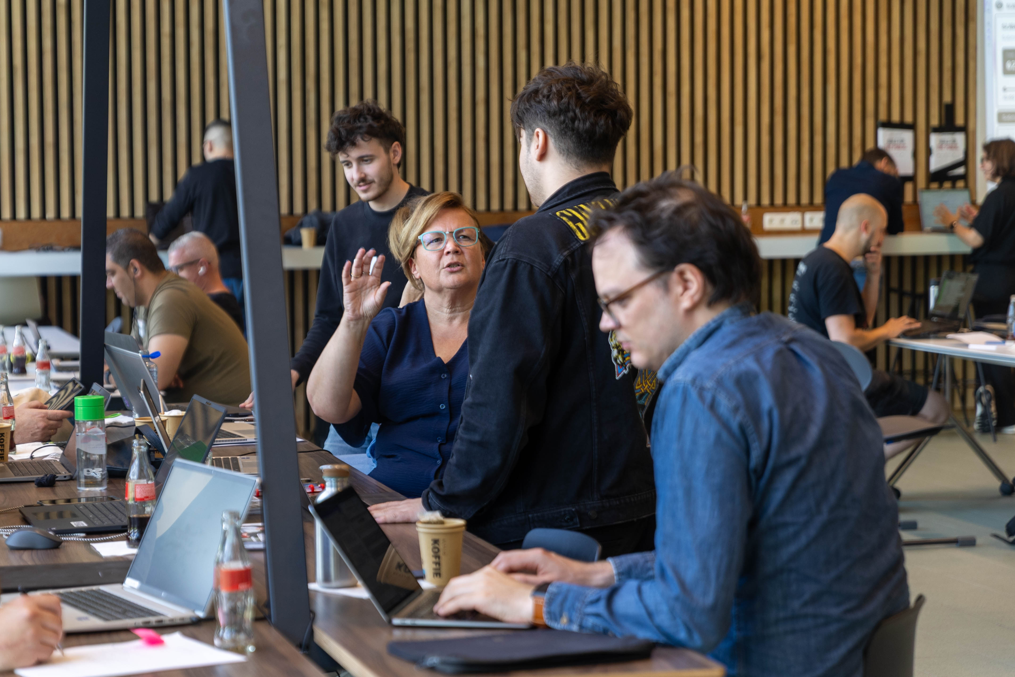 A participant and builder discuss a challenge at a hackathon.