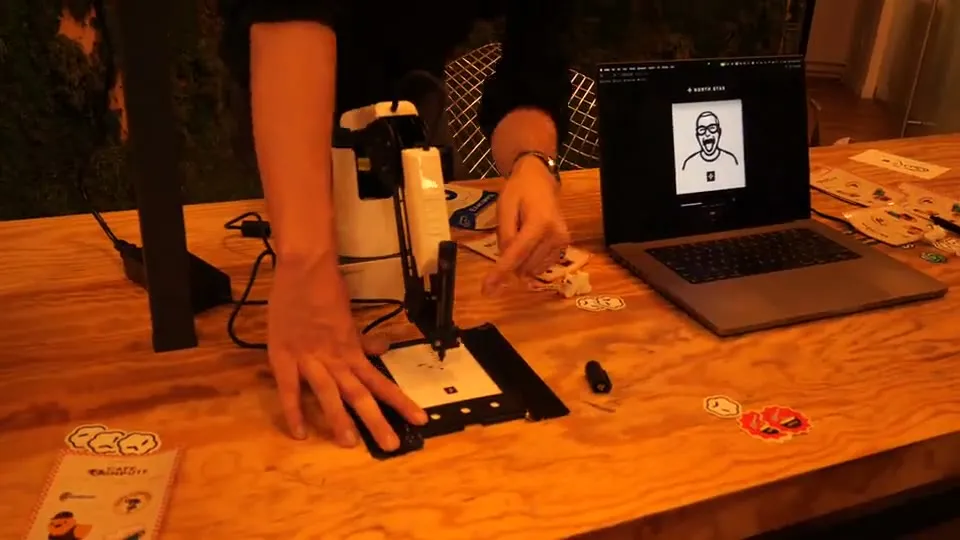 MARK-E tekent met een robotarm een portret op een kaartje